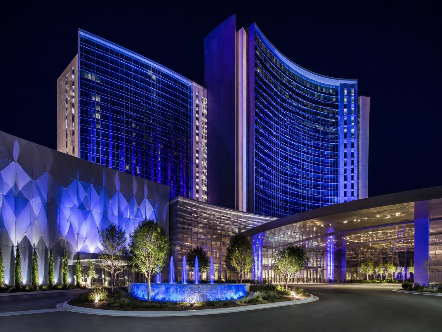 Illuminated casino resort facade with arched entrance portico at night
