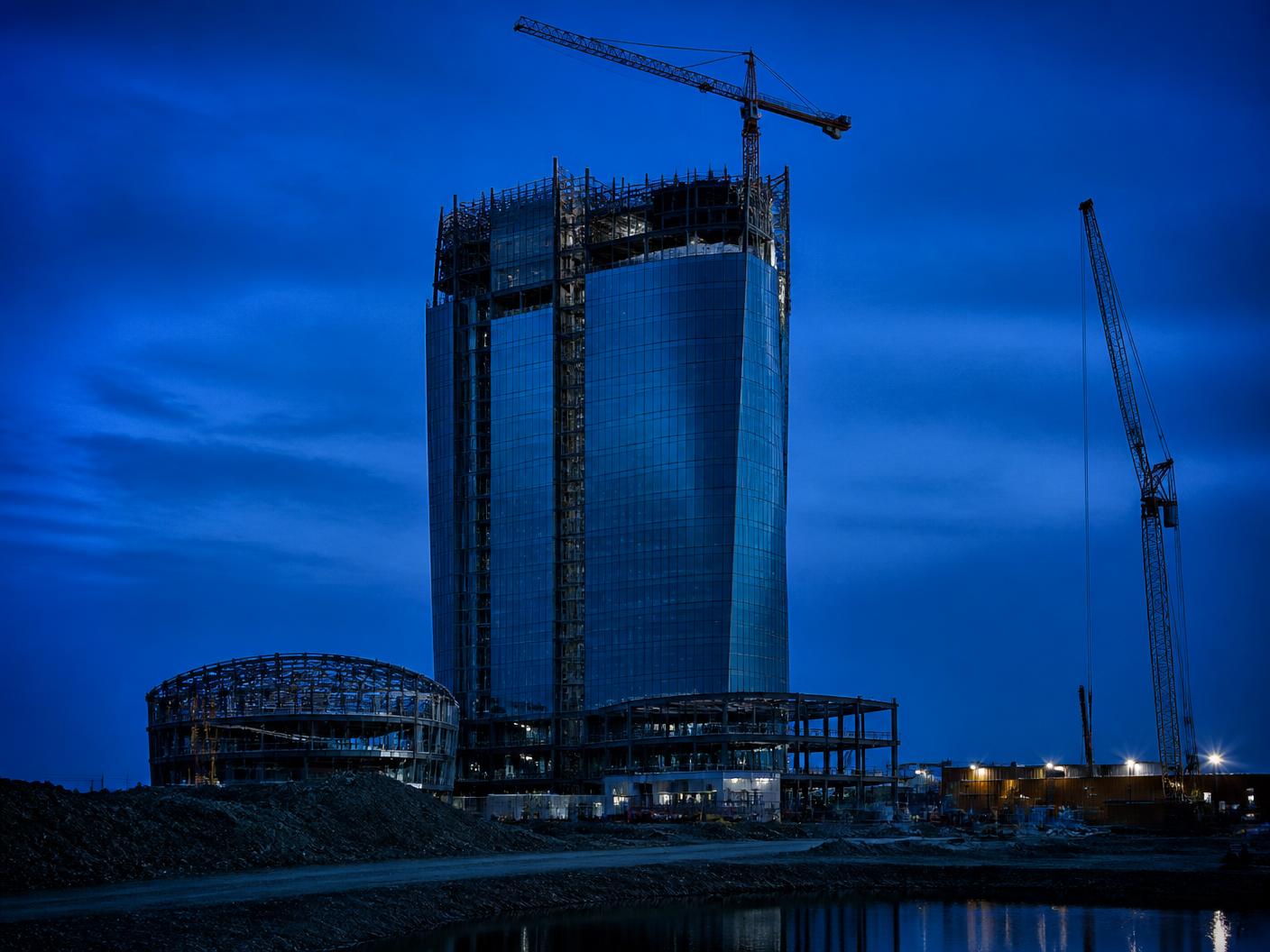 Integrated casino resort tower under construction at dusk